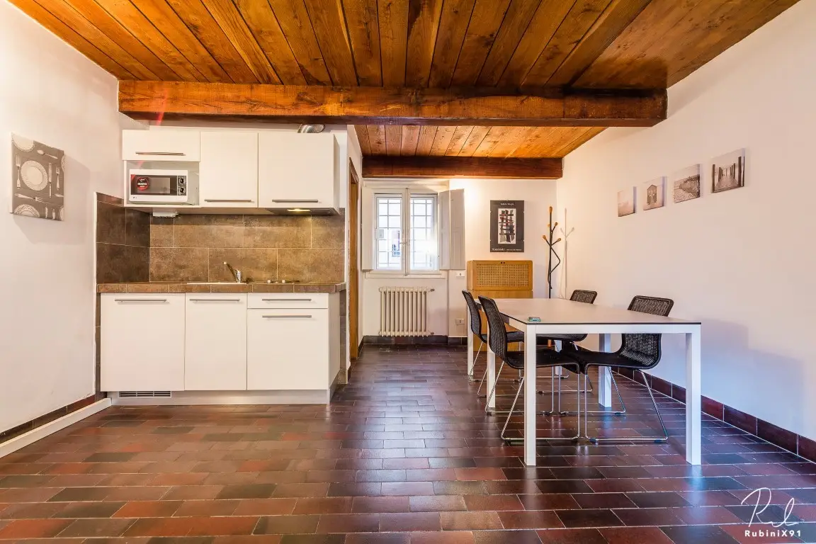 Cocina americana con techo de madera vista y mesa de comedor