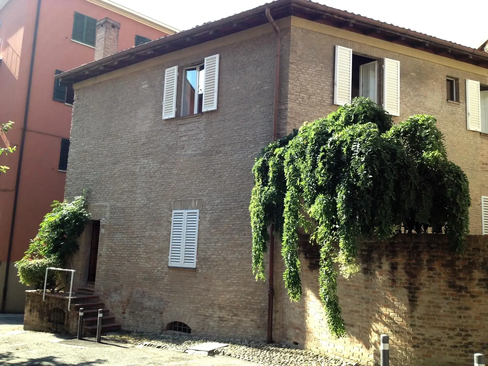 El edificio de ladrillo de Via Vallescura, con la planta colgante sobre el muro