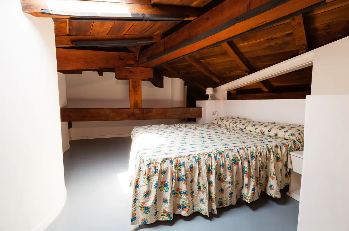 Bed on the mezzanine under the exposed timber roof