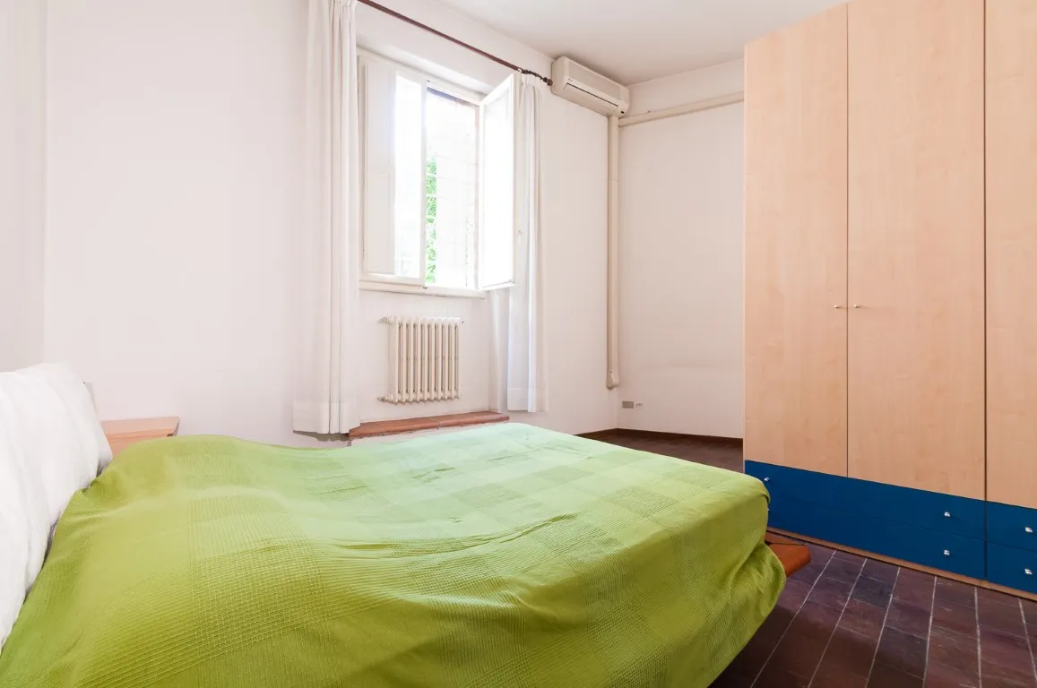 Dormitorio con armario, ventana al verde y aire acondicionado