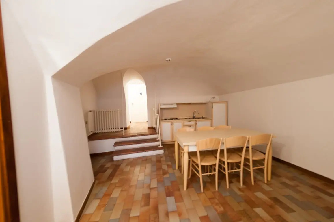 Soggiorno con soffitto a volta e zona pranzo con angolo cottura